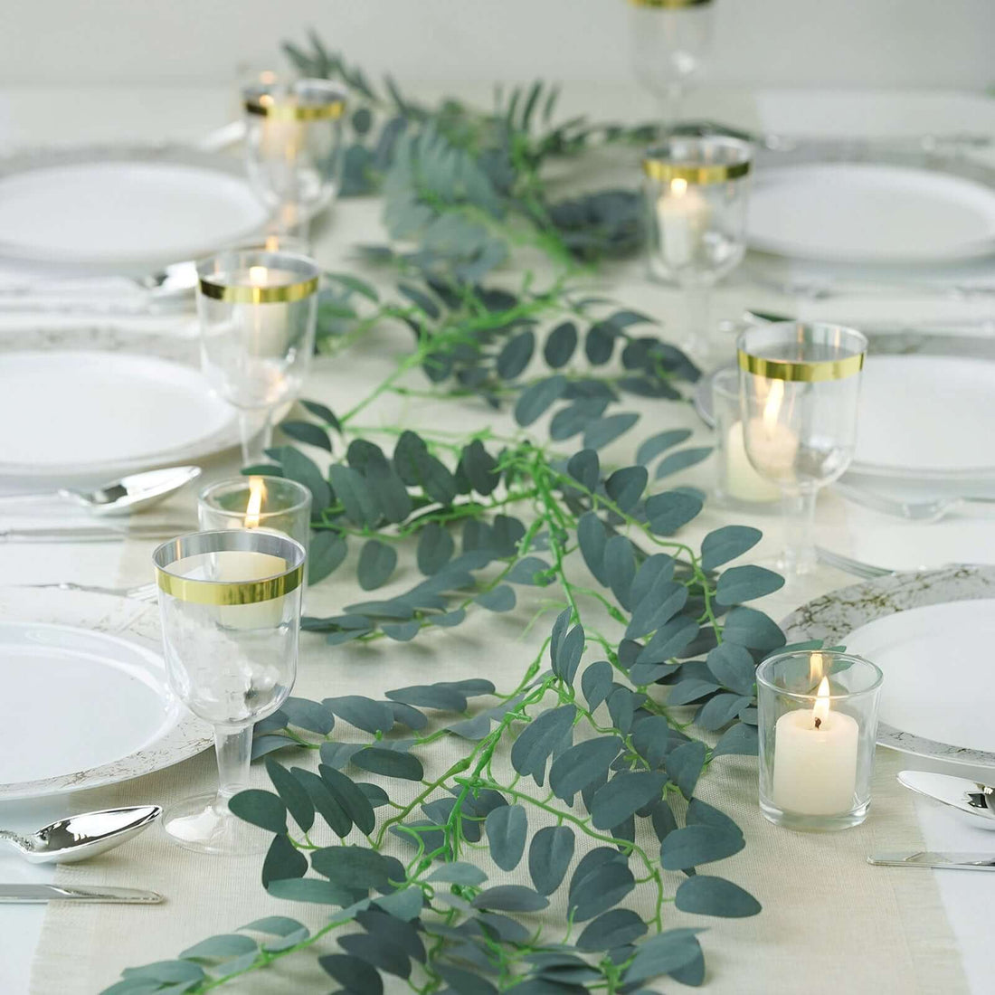 Elegant table setting with greenery, candles, and dinnerware for a stylish dining experience.