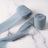 Light blue fabric ribbon rolls on a marble surface.