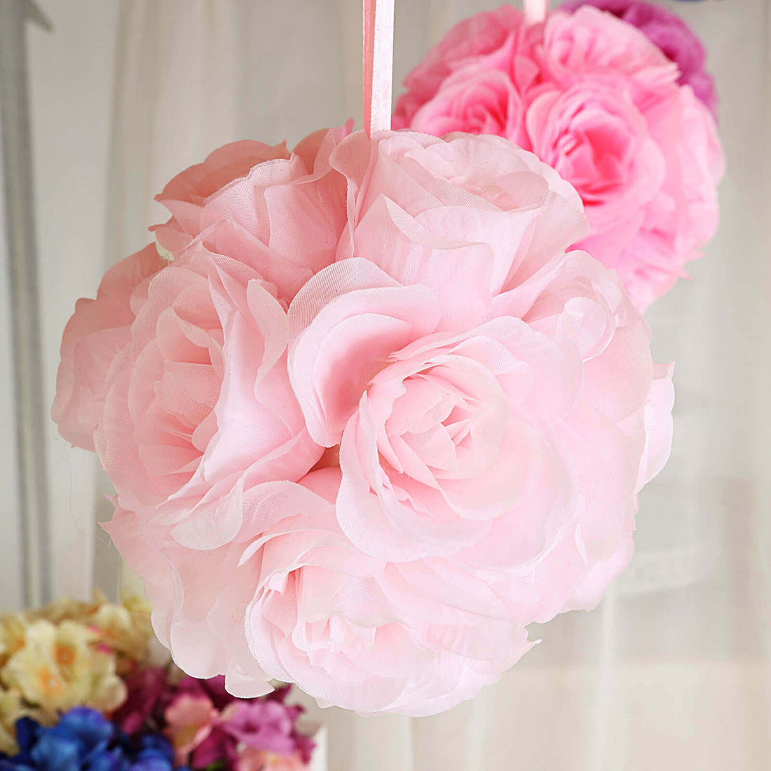 Pink paper flower decoration hanging in a soft, airy setting.