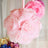 Pink paper flower decoration hanging in a soft, airy setting.