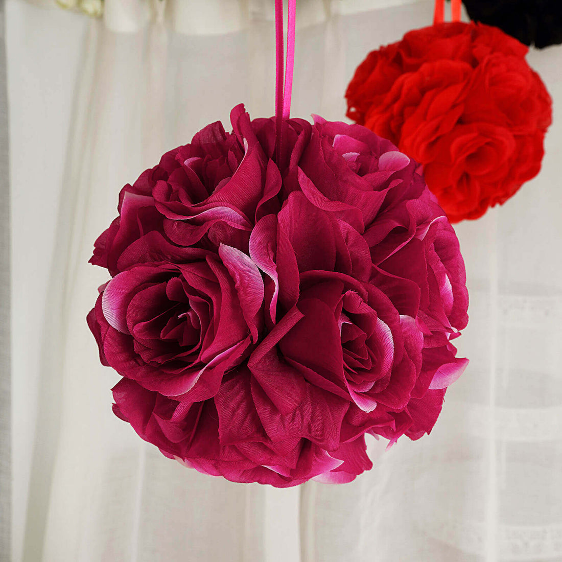 Pink floral ball decoration hanging against a light background.