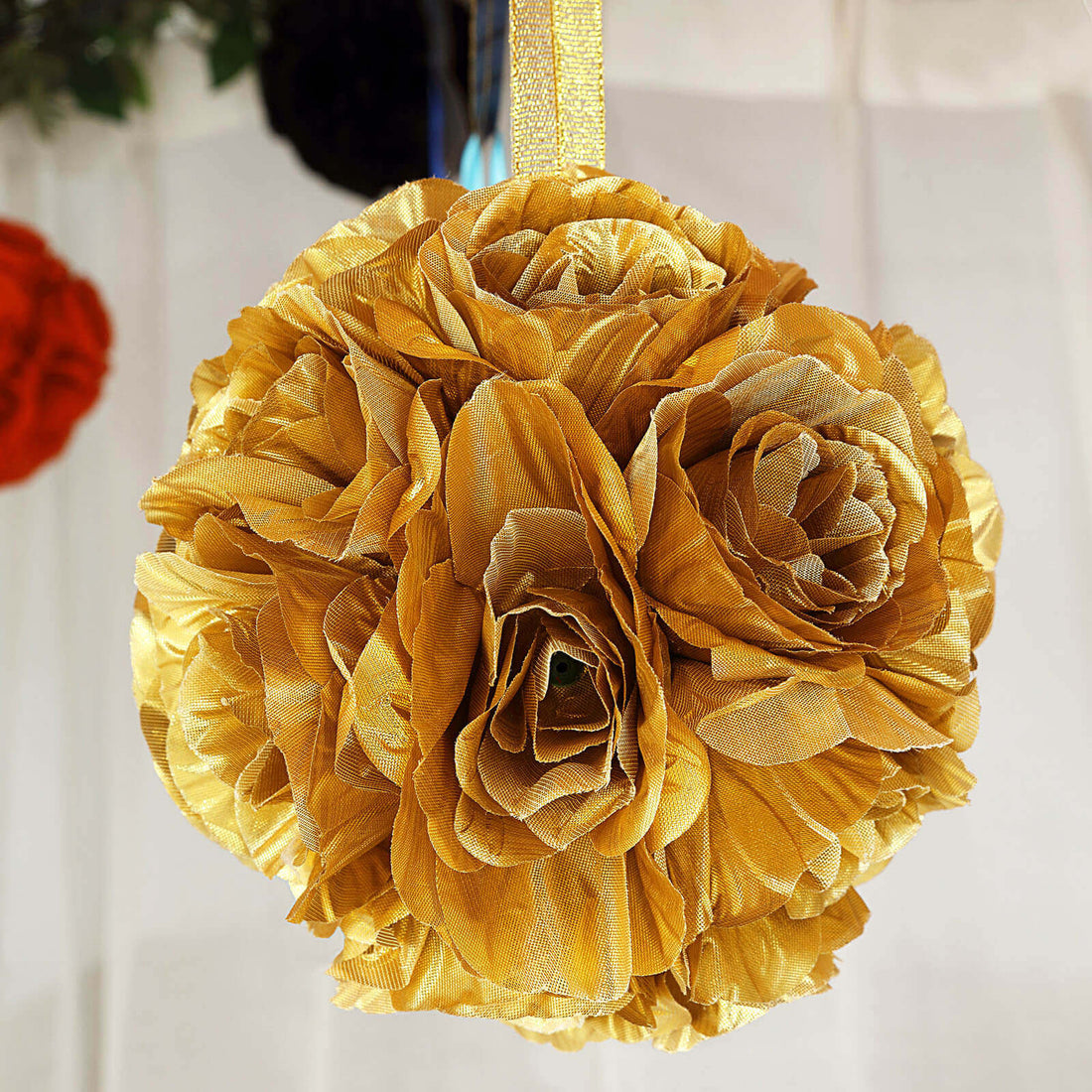 Golden fabric flower ball decoration hanging on ribbon.