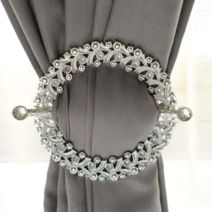 Elegant silver curtain tieback with intricate design and decorative gems.