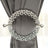 Elegant silver curtain tieback with intricate design and decorative gems.