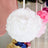 White floral ball decoration hanging on a display.