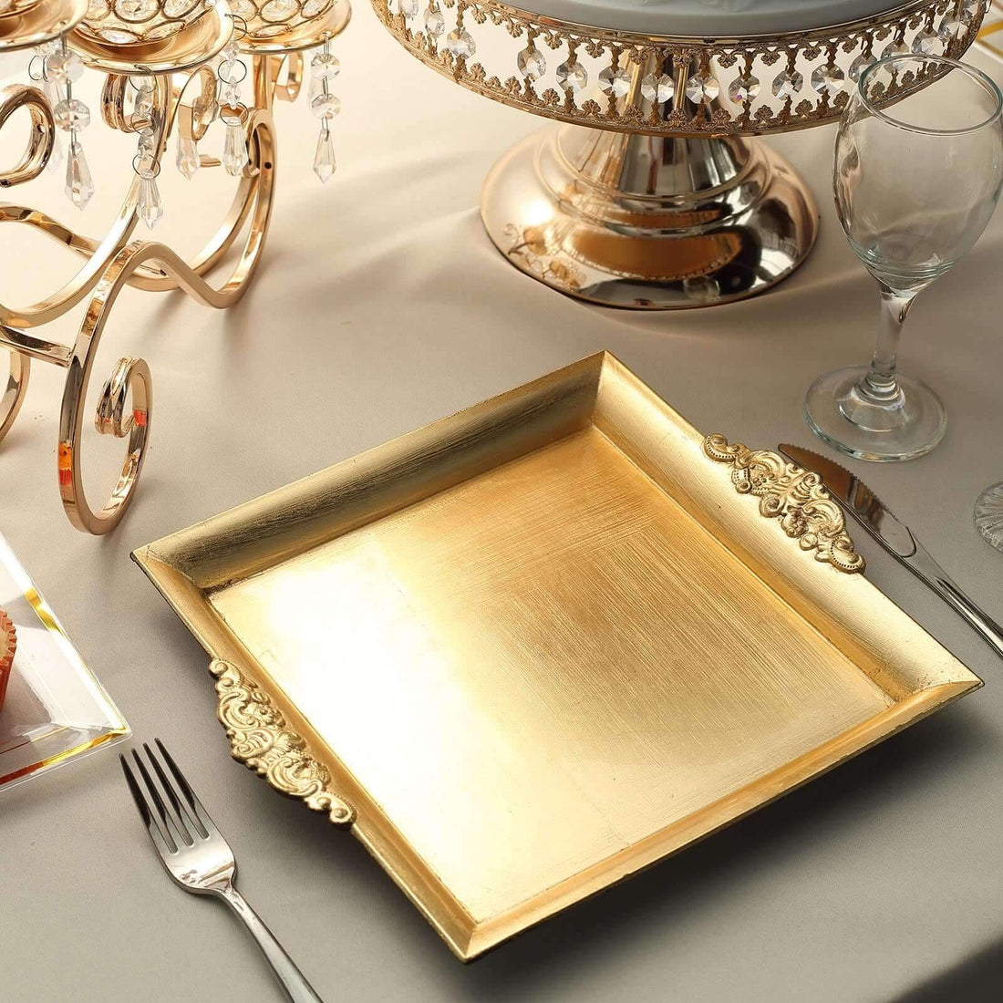 Elegant gold serving tray with ornate handles on a festive table setting.