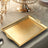 Gold decorative serving tray on a stylish table setting.