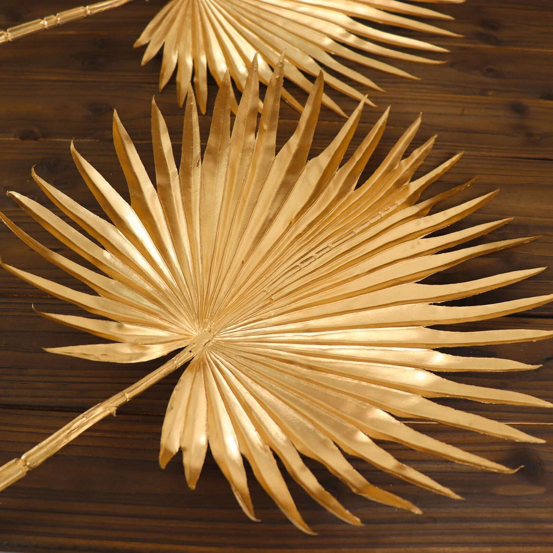 Gold palm leaf decor on wooden surface, perfect for home styling. #whtbkgd