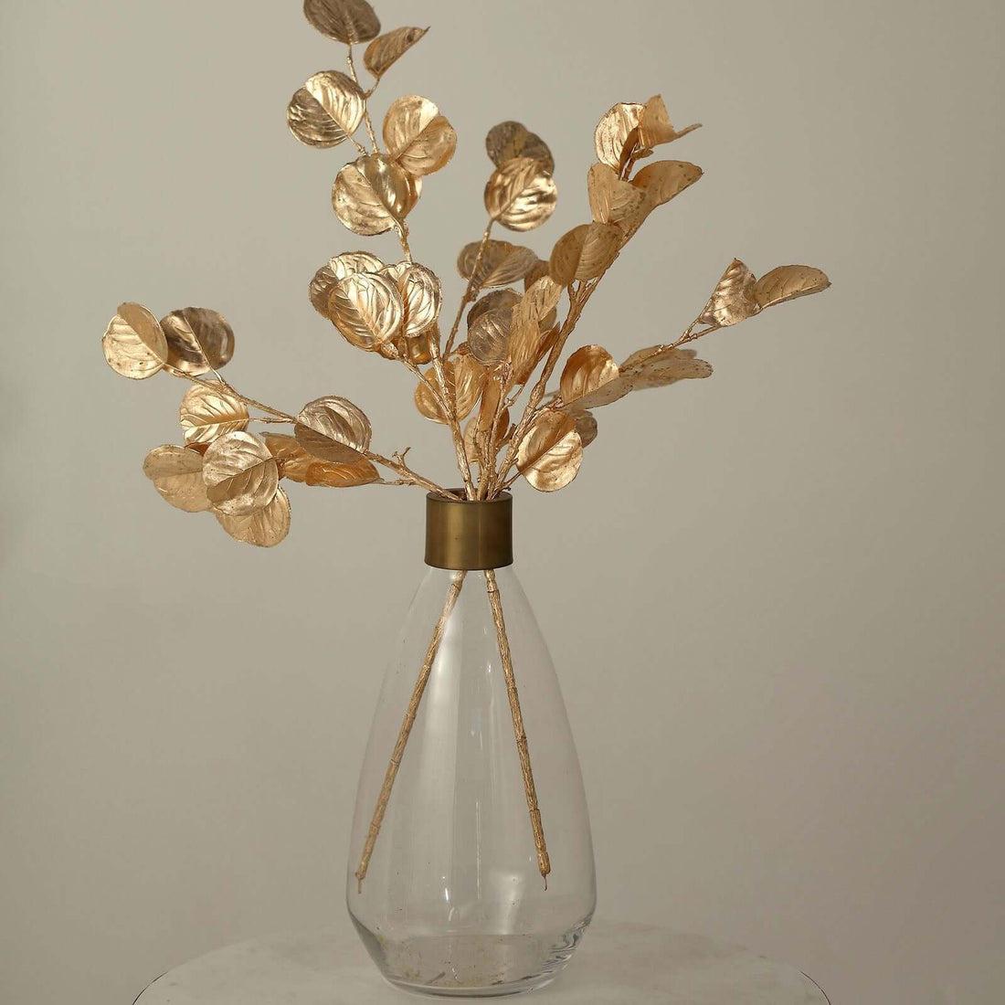 Gold leaf branch arrangement in a clear vase.