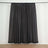 Sheer dark gray curtain panel hanging on a rod