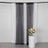 Black sequin curtain draped with white fabric and a floral arrangement in a vase.