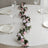 Floral table runner with pink and white roses on a dining table.