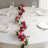 Floral table runner with pink and white flowers on a dining table setting.