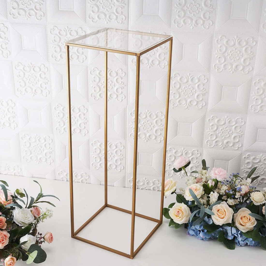 Gold metal display stand with clear top, ideal for showcasing decor.