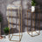 Gold metal plant stands with modern design against a textured background.