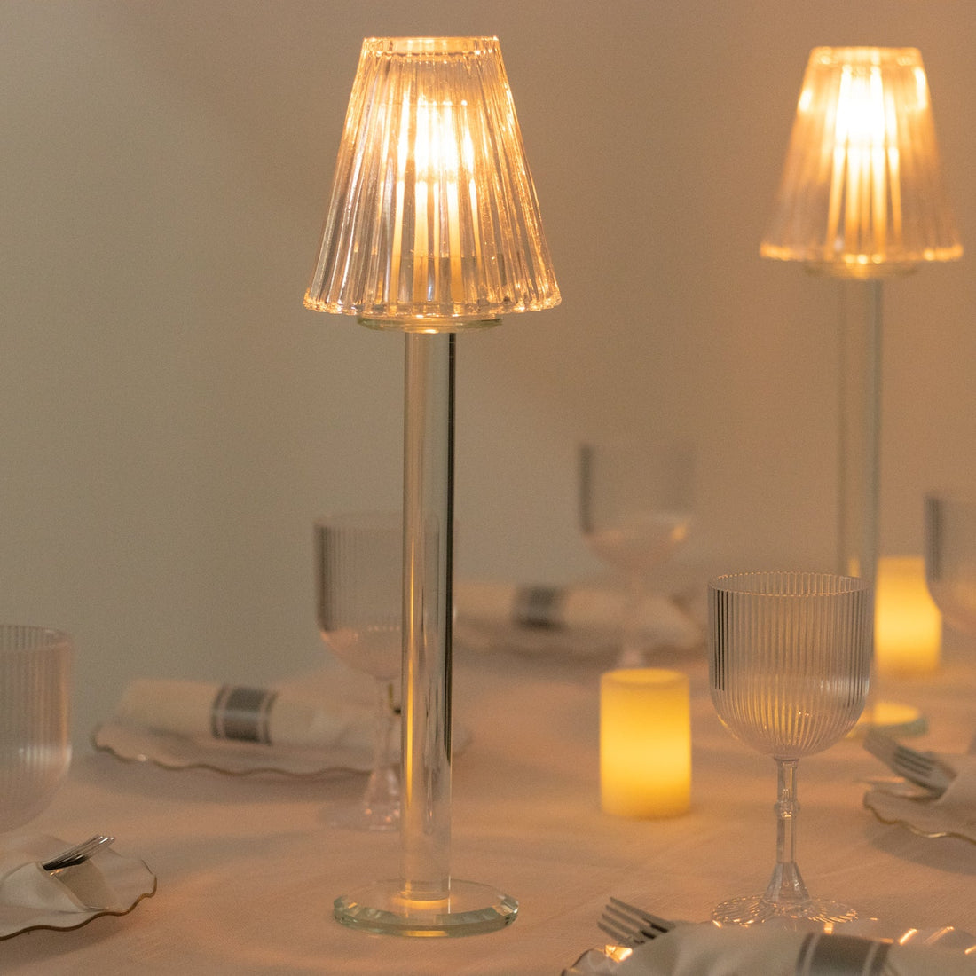 Elegant table lamp with a pleated shade, illuminating a stylish dining setup.
