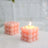 Pink bubble candle with a lit wick on a soft background.