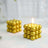 Gold decorative candle in a unique spherical design, lit with a warm glow.