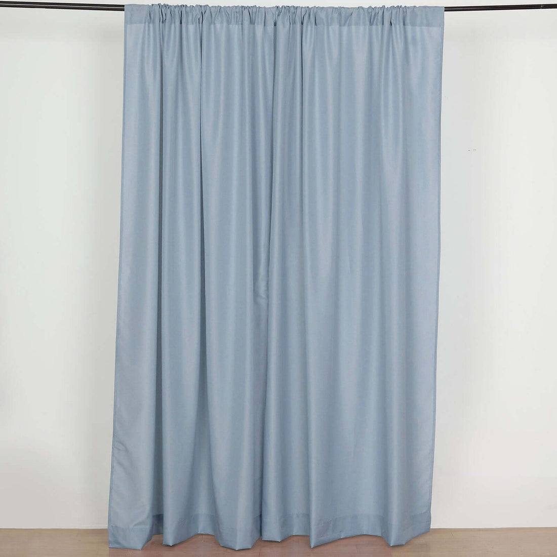 Light blue curtain draped on a rod, showcasing soft fabric texture.