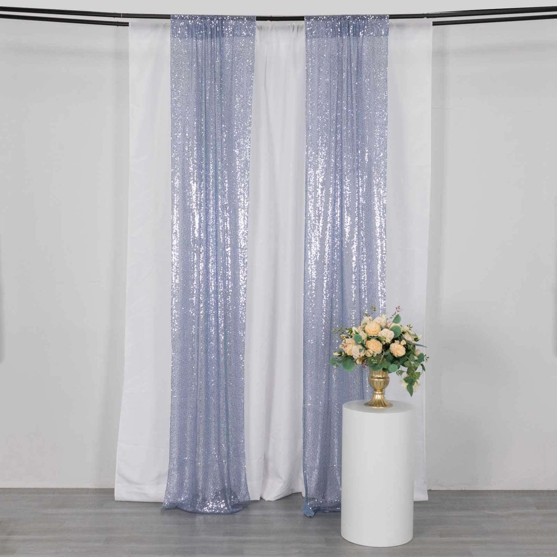Lavender sequin curtains draped in a studio setting with a floral arrangement.