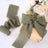 Olive green fabric ribbon tied around a gift box with flowers