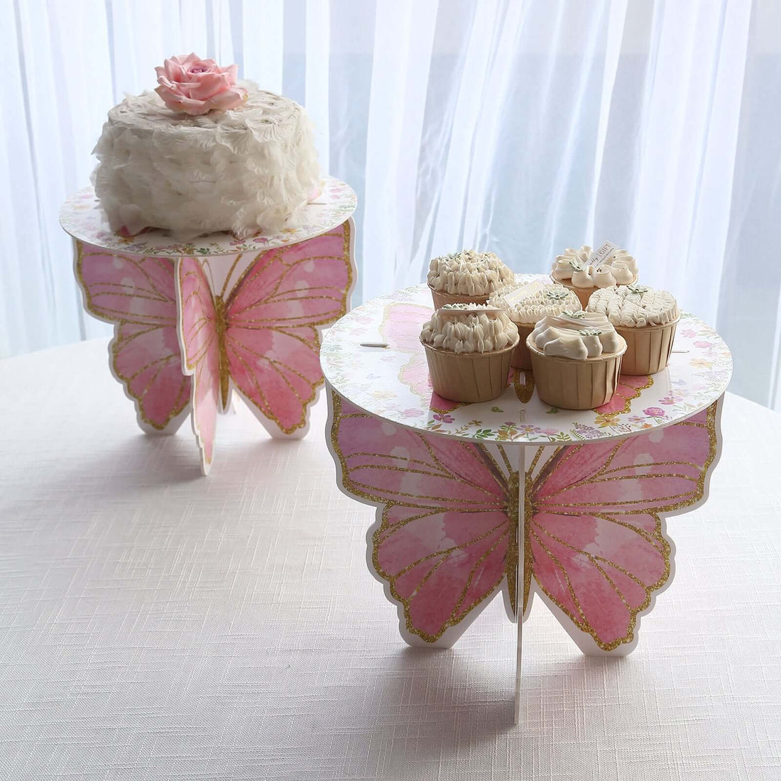Butterfly-themed cake stand with a cake and cupcakes on display.