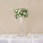 Tall glass vase with a floral arrangement on a dining table setting.