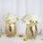 Gold vases with white roses, elegant decor for any setting.