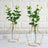 Decorative vases with greenery on a marble surface.