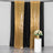 Gold sequin backdrop curtains with a floral arrangement on a white pedestal.
