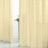 Sheer beige curtains draping elegantly in a bright room with a plant.