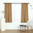 Brown curtains on a rod with a white sheer curtain in a modern living space.