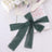 Dark green sheer ribbon elegantly tied on a book with decorative elements.
