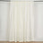 Cream curtain panel with a smooth finish hanging on a curtain rod.