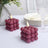 Purple bubble candle design with lit wick, set on a table with dining ware.