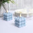 Blue bubble candles on a dining table with elegant glassware and plates.