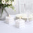White bubble candles on a table with flowers and glassware.