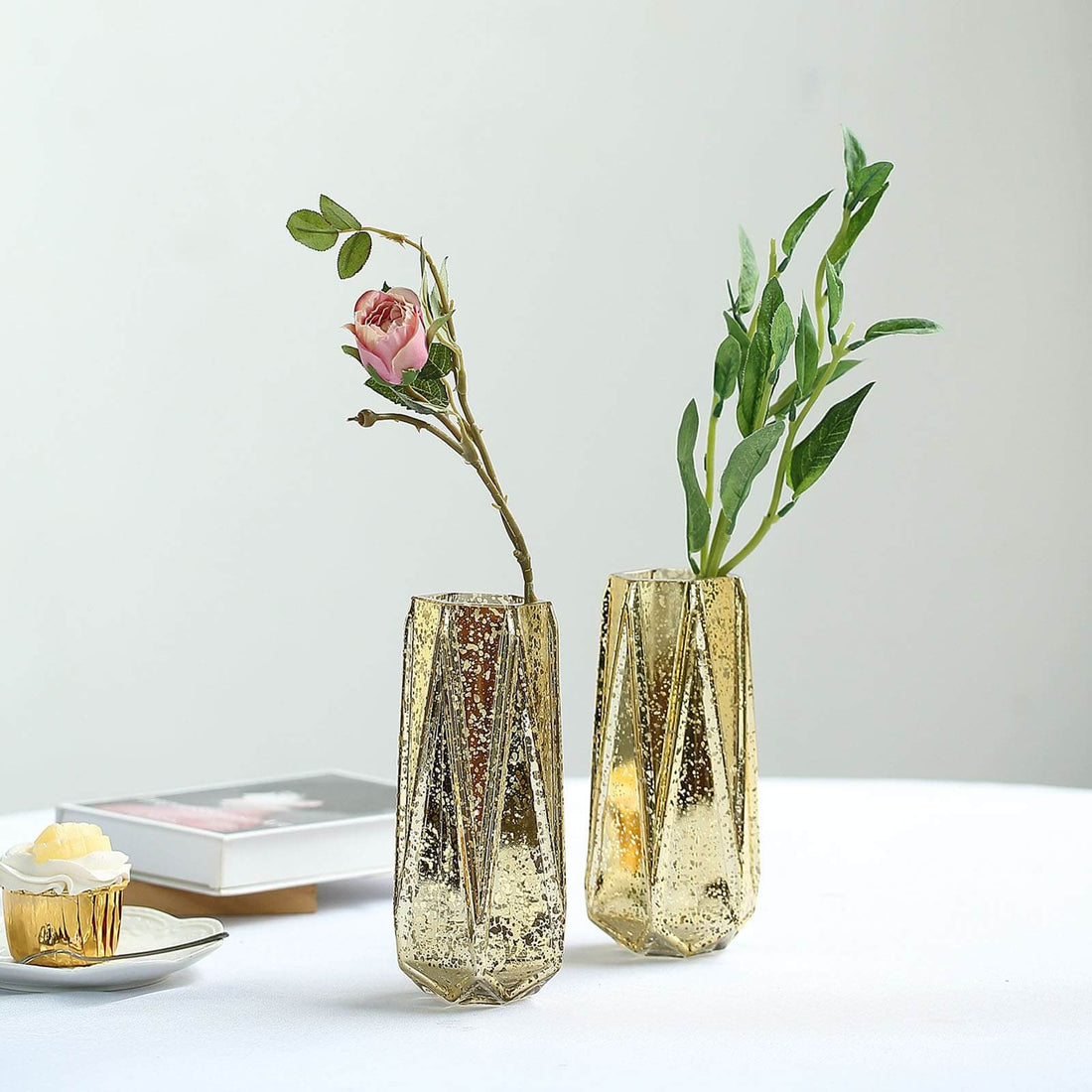 Gold geometric vases with flowers on a table