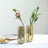 Gold geometric vases with flowers on a table