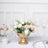 Gold vase with pink and white roses, styled for a dining table setting.