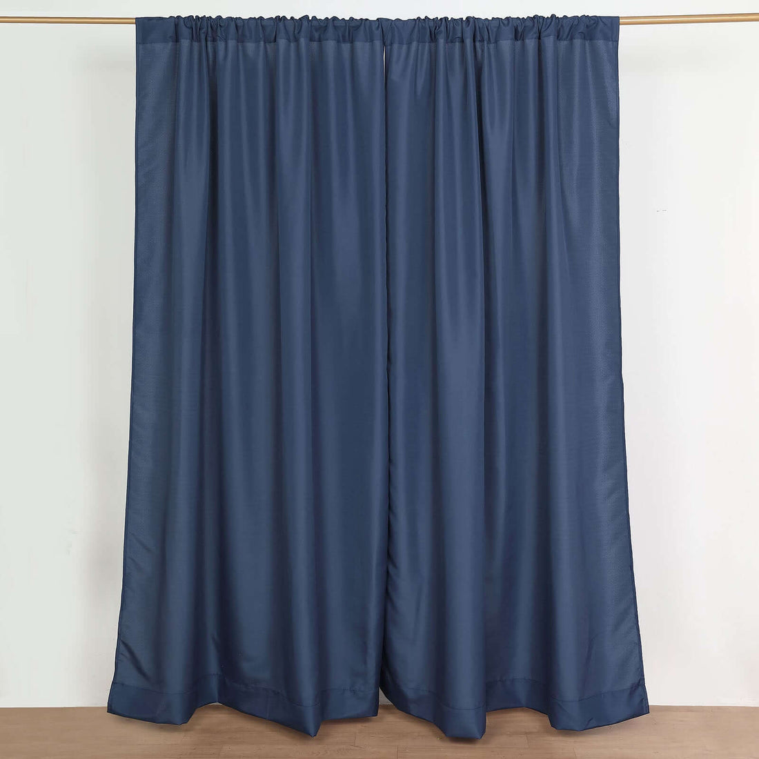 Navy blue curtain panels hung on a rod in a studio setting