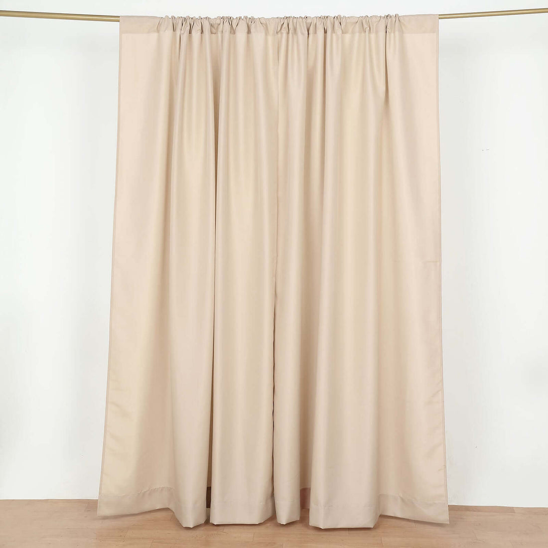 Beige curtain panel with gathered top on a plain backdrop