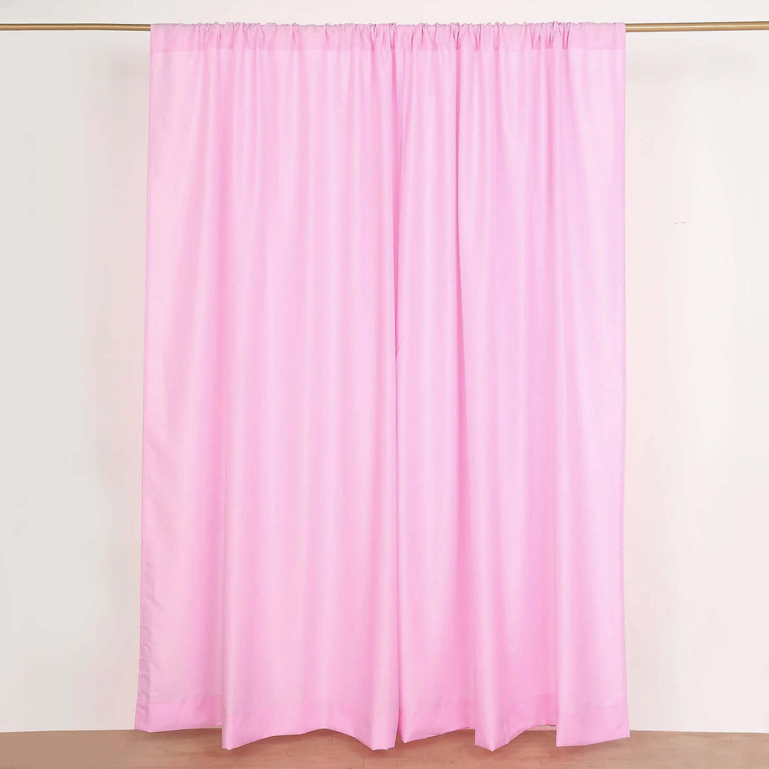 Pink fabric curtain draped on a rod