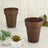 Copper plant pots with succulents on a marble surface.