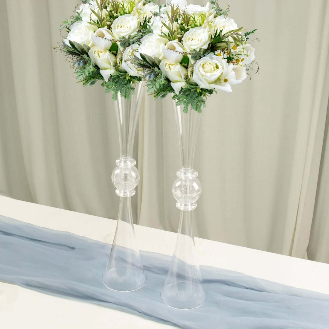 Elegant white floral arrangements in clear glass vases.