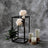Floral arrangement with peonies and candles on a textured backdrop.