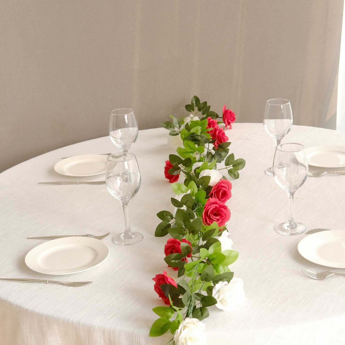 Elegant table setting with roses and glassware for a special occasion.