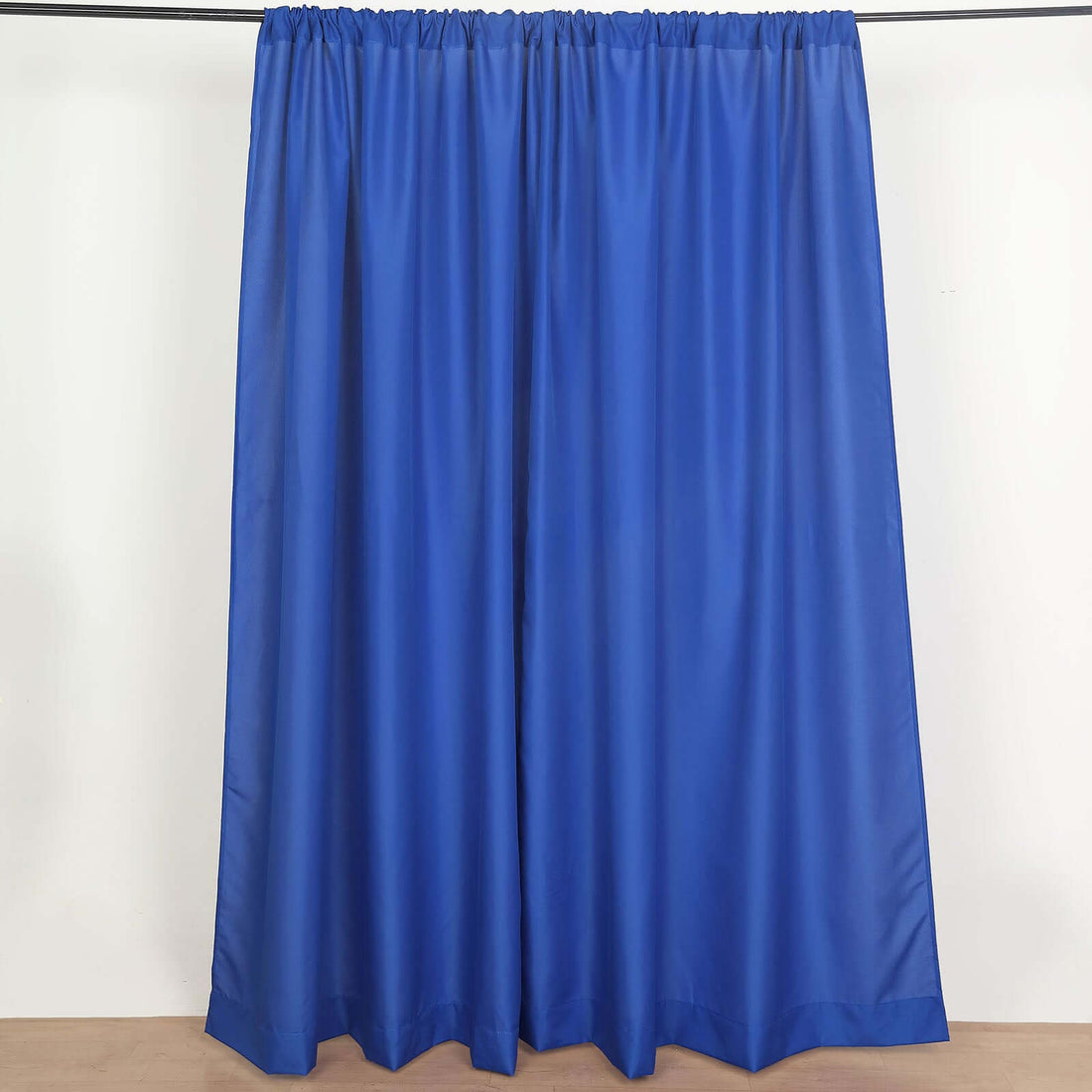Blue curtain drapes hanging on a rod, showcasing a smooth fabric texture.