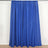 Blue curtain drapes hanging on a rod, showcasing a smooth fabric texture.