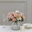 Pink flower bouquet in a glass vase with elegant table setting.
